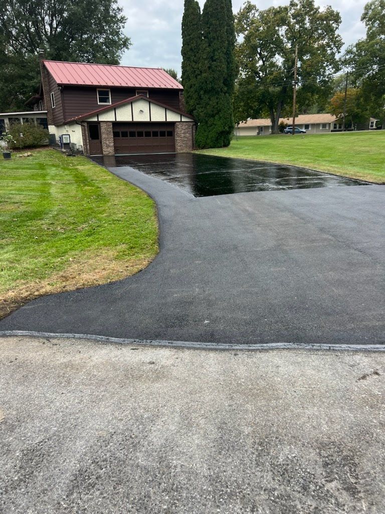 a driveway leading to a house with a red roof .