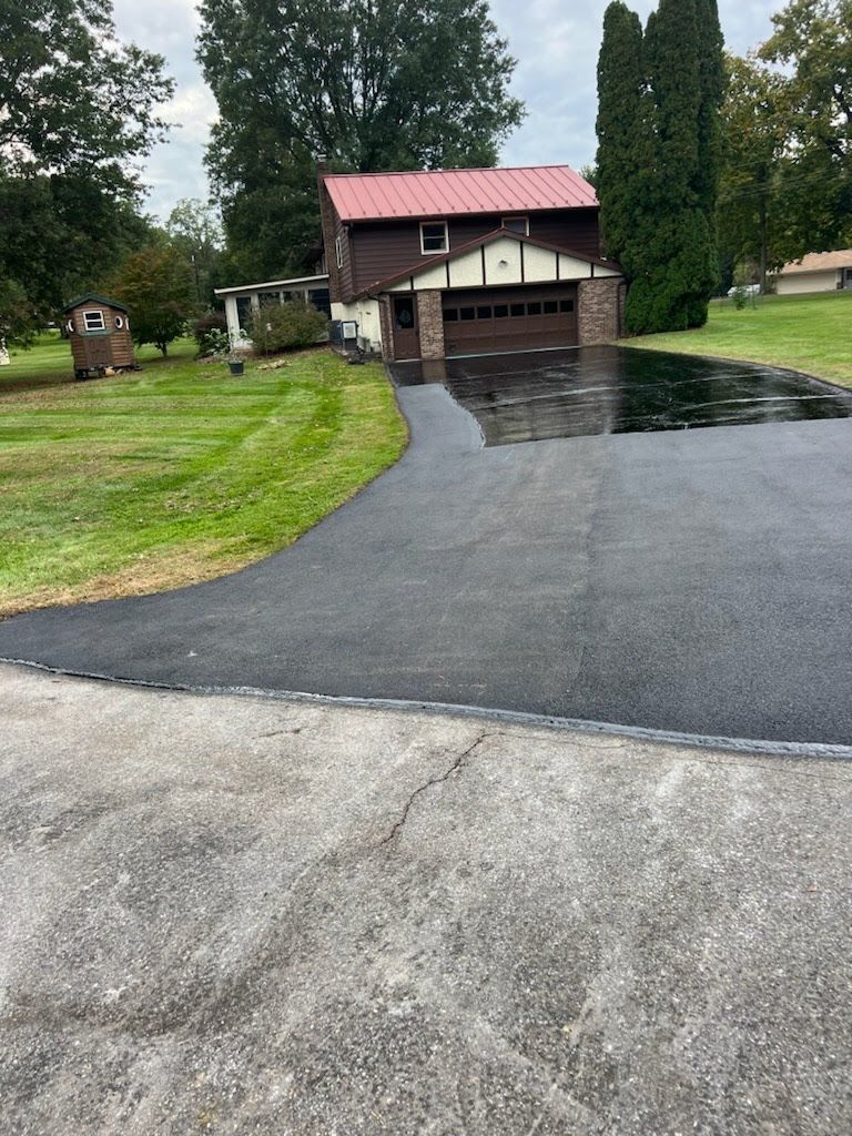 a driveway leading to a house with a red roof