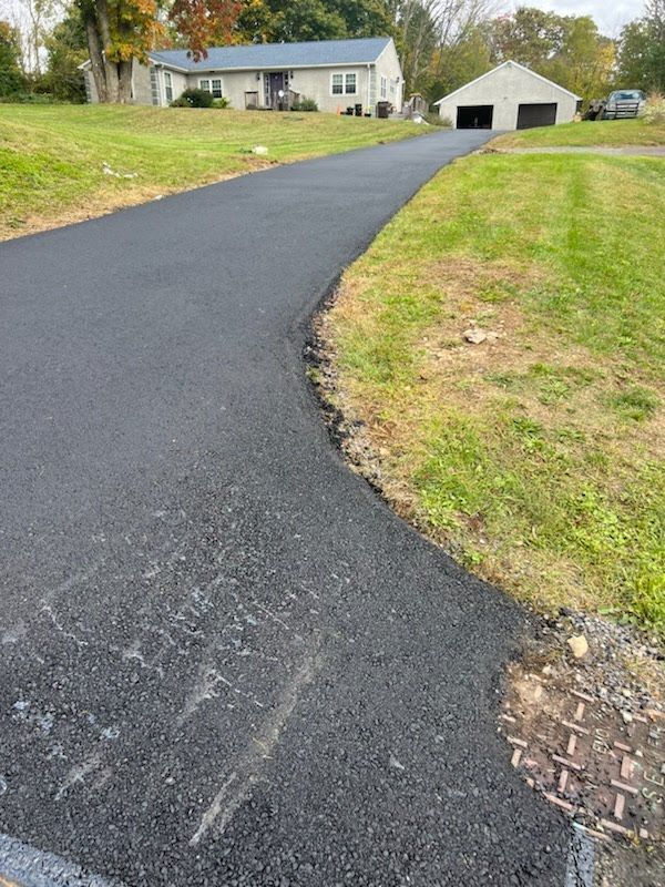 a driveway leading to a house with a garage in the background .
