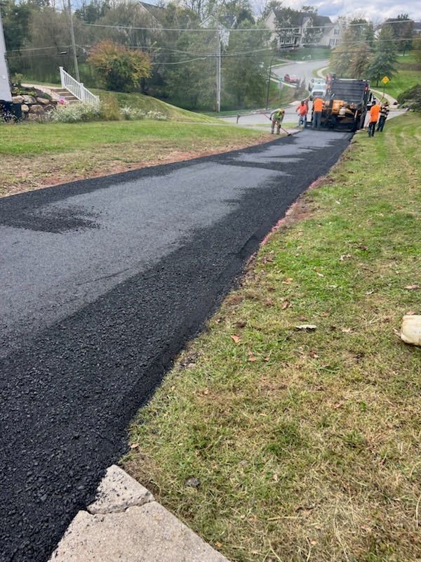 a group of people are standing on the side of a road .
