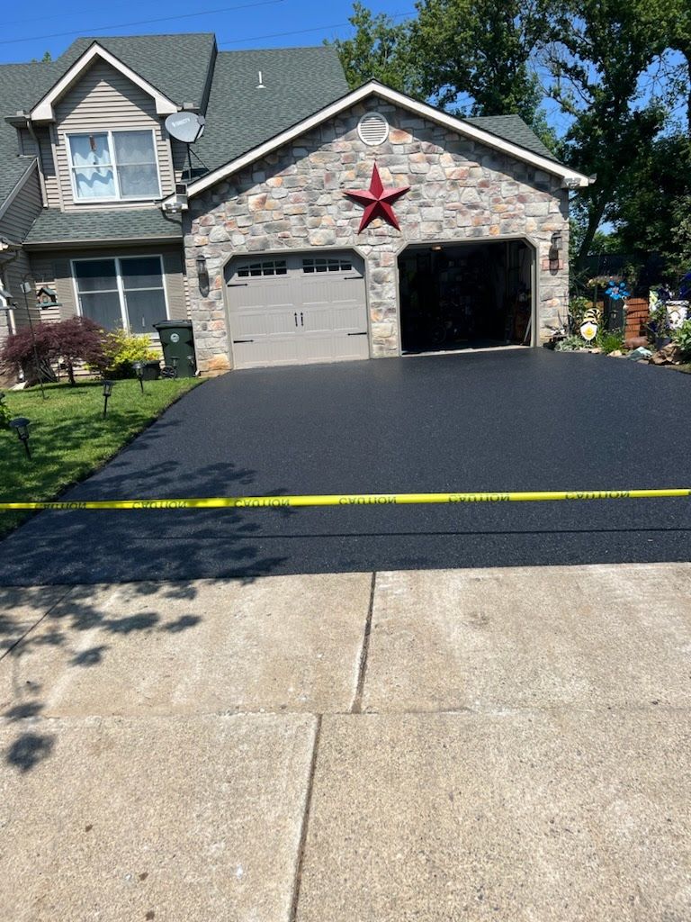 a house with a large driveway and a red star on the front of it .