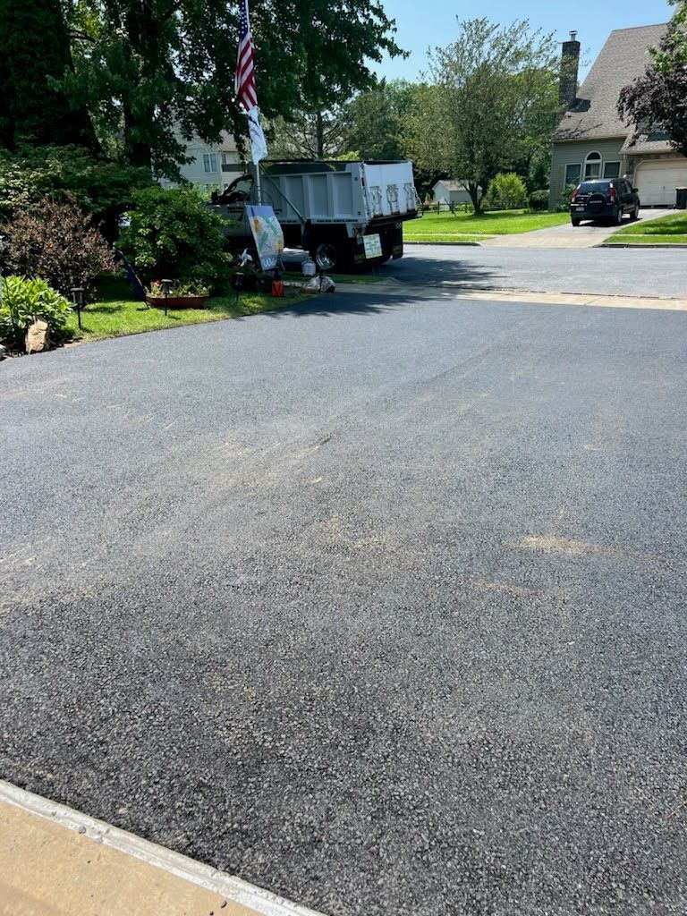 a dump truck is parked in a driveway next to a house .