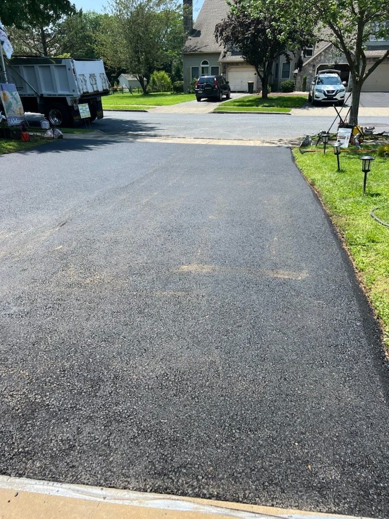 a truck is parked on the side of the road in a driveway .