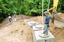 Three men working on a septic system