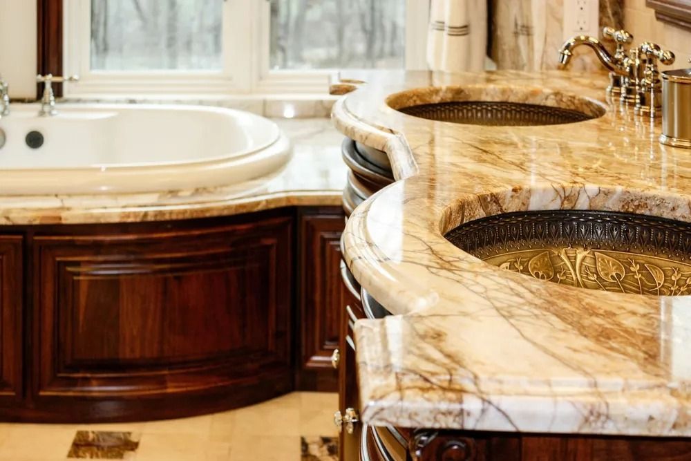 Bathroom with marble countertops, sinks, and a bathtub with a wood cabinet.