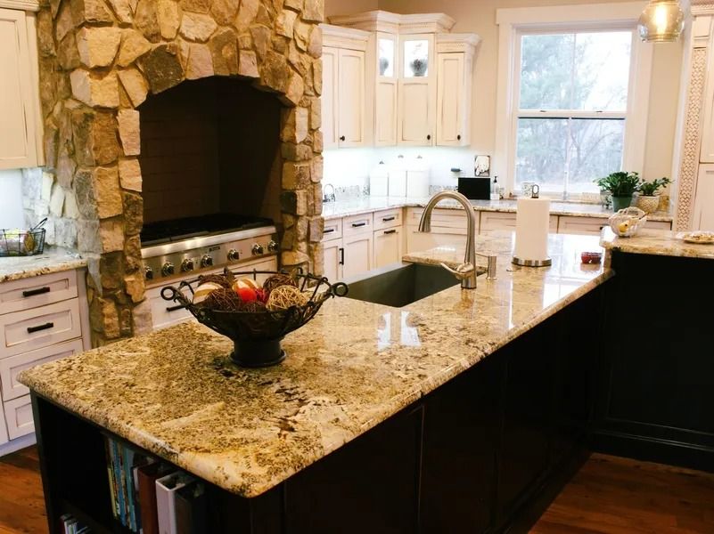 Kitchen with stone range hood, granite countertops, and dark island.