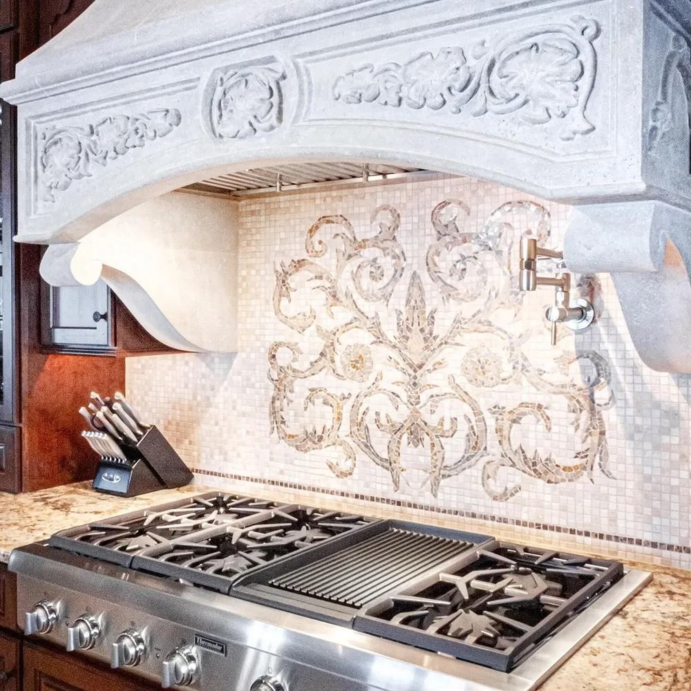 Kitchen with stainless steel stove, decorative backsplash, and ornate range hood.