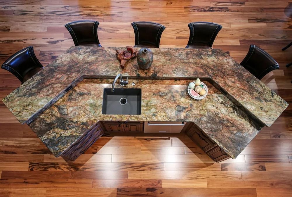 Overhead shot of a kitchen island with dark granite countertop, sink, and seating for five.