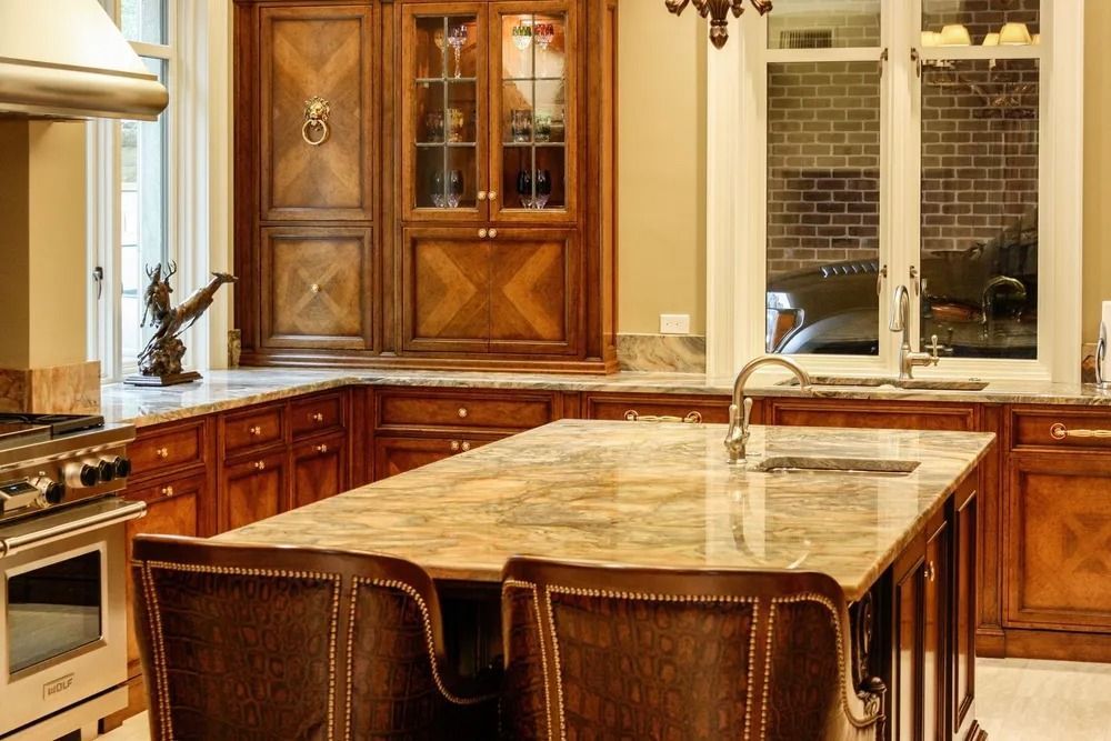 Elegant kitchen with a large island, brown cabinetry, and a granite countertop.