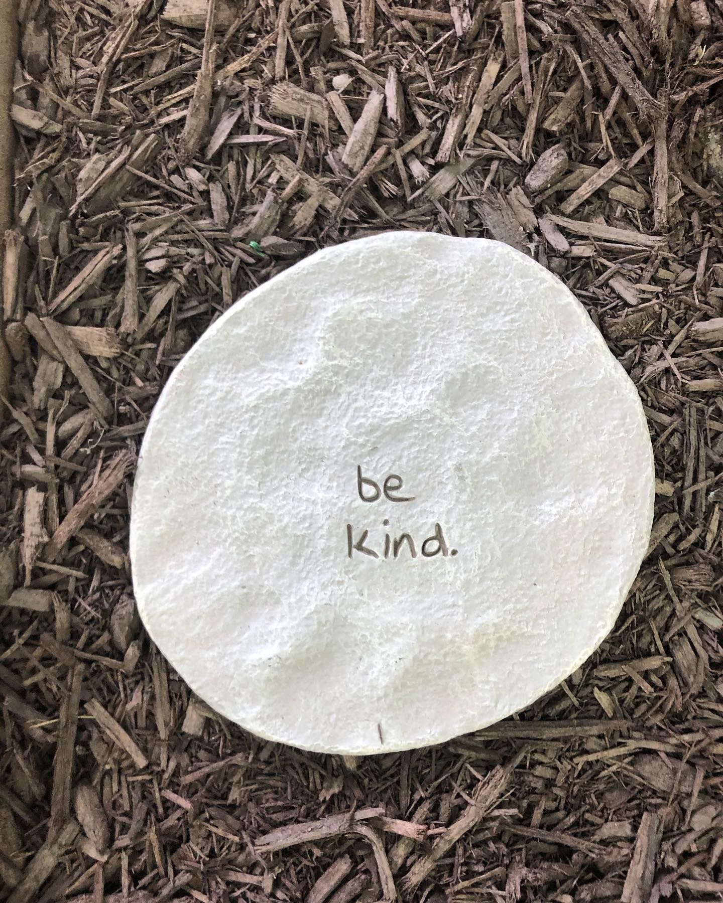 A round, light-colored stone with the words 