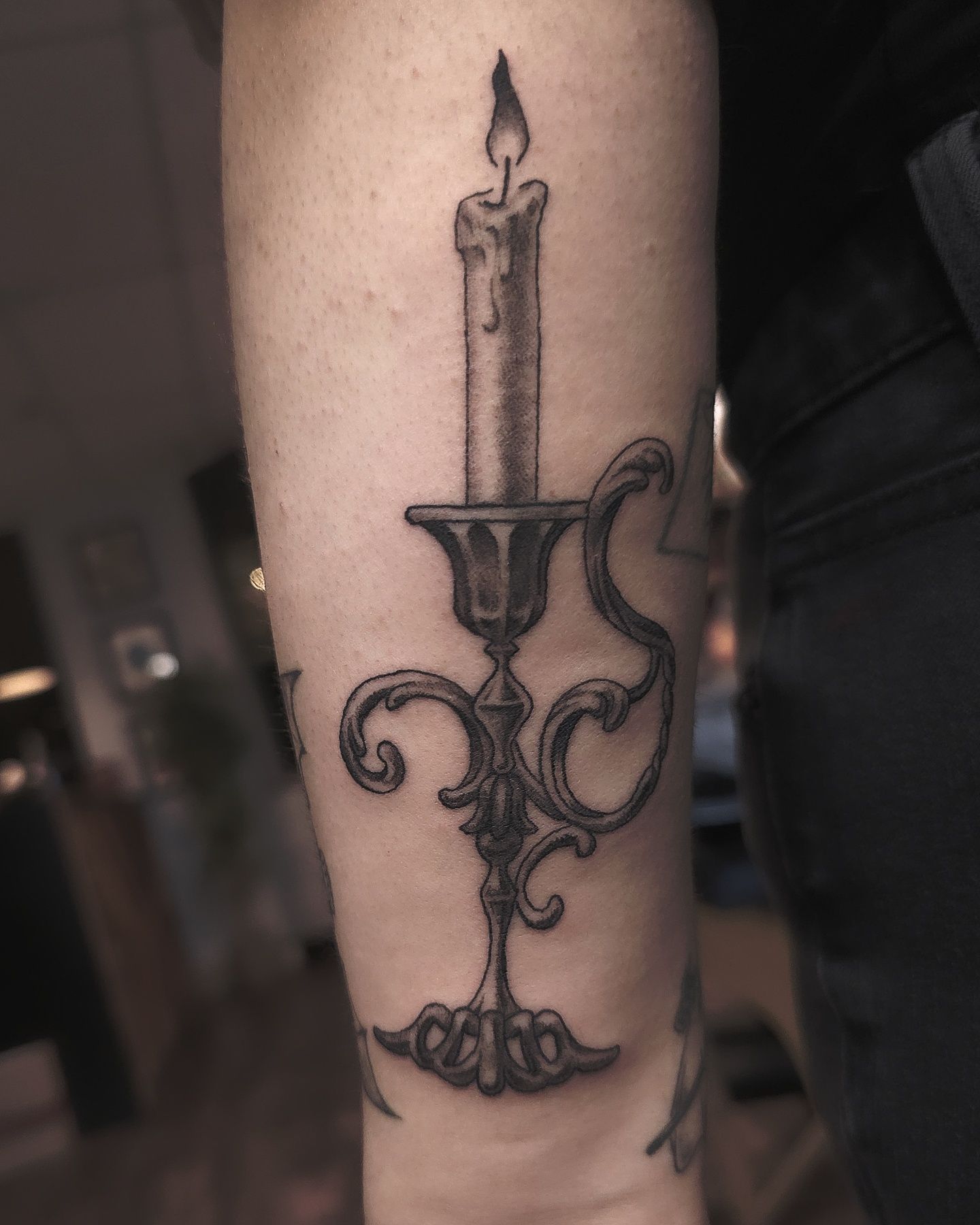 Tattoo of a candle in a candle holder
