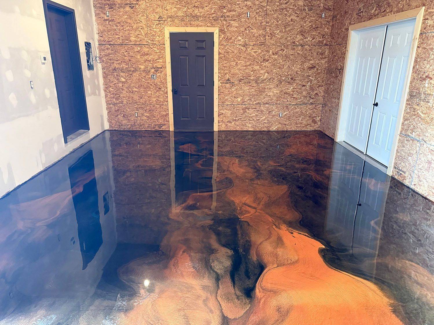 Glossy epoxy floor in a room with beige walls and white doors, reflecting the interior.