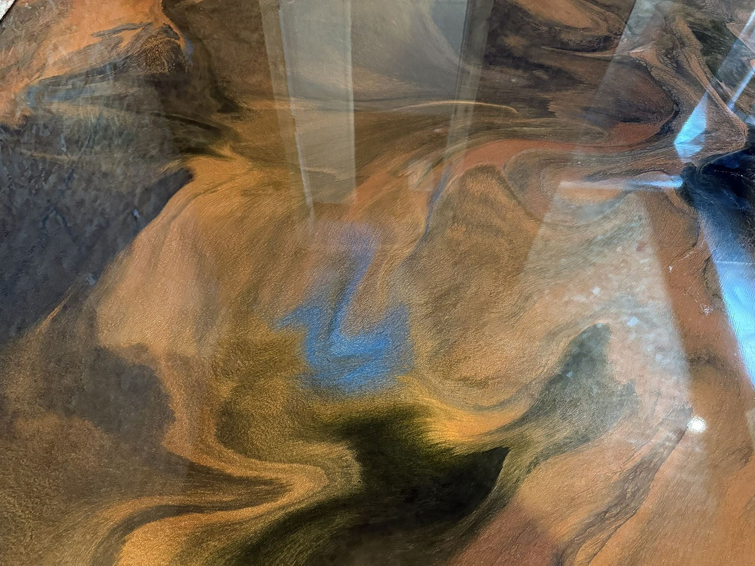 Abstract close-up of wrinkled brown and orange fabric with a dark central fold and blue highlights.