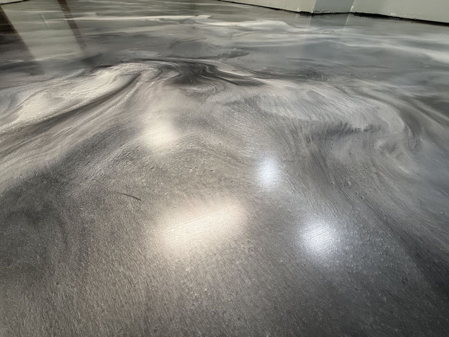 Smooth gray concrete floor with light reflections in an indoor space.
