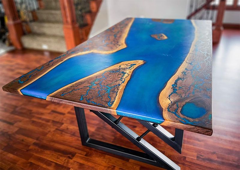 Blue-and-gold resin dining table with wood accents in a room