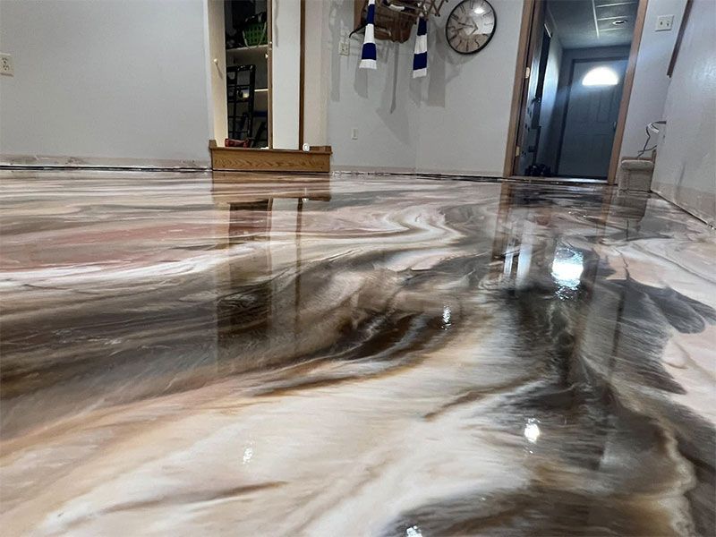 Swirled brown-and-white epoxy floor in a hallway with reflections and wall decor