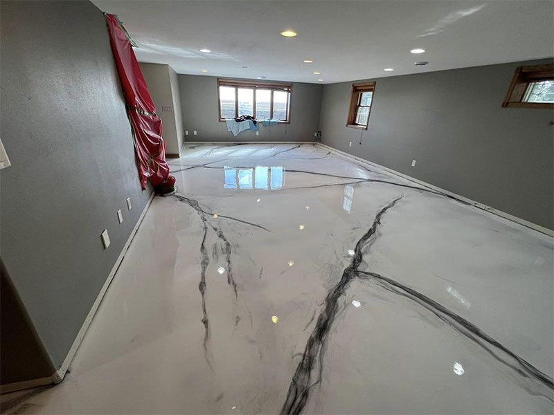 Empty modern room with glossy white marble-pattern floor and gray walls, seen from one end