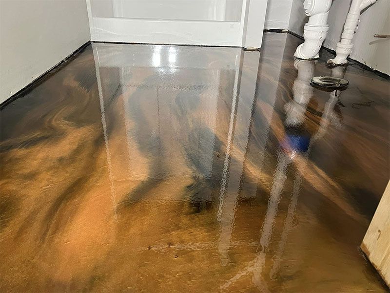 Shiny dark wood floor with water damage and reflections near a doorway