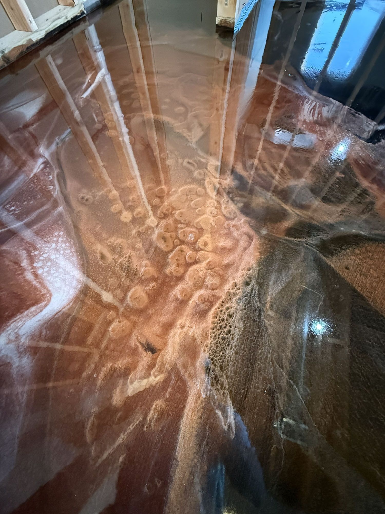 Close-up of a glossy brown abstract surface with bright white vein-like lines and reflections from windows.