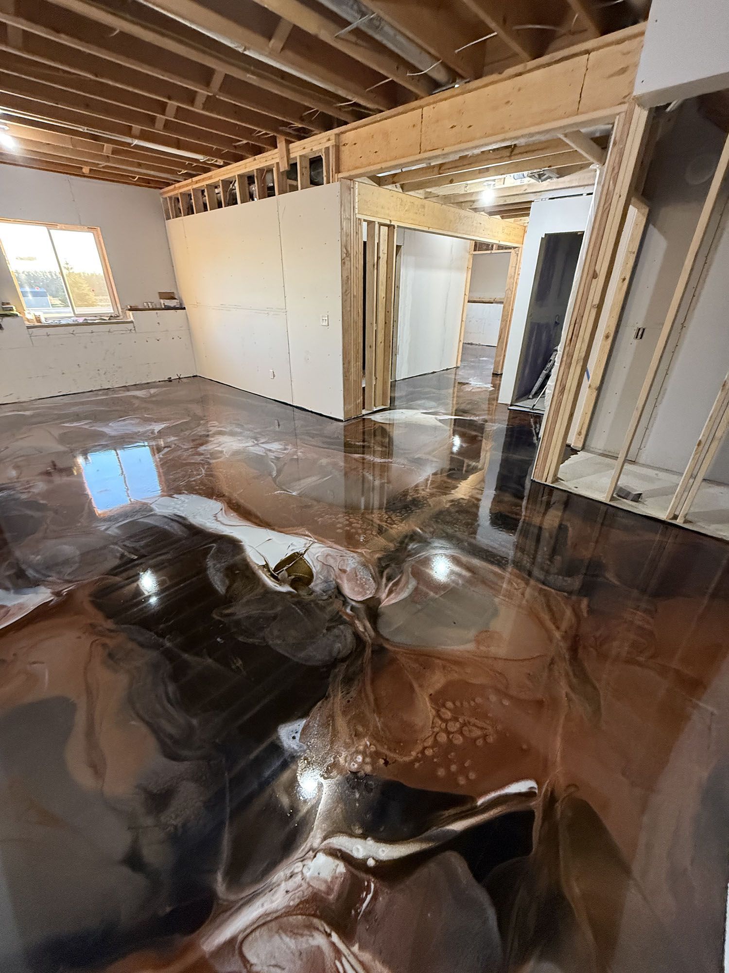Flood-damaged room with standing water, exposed ceiling joists, and wet debris on the floor.