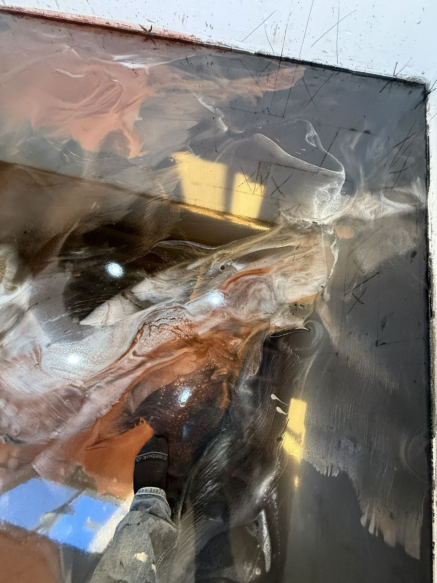 Abstract close-up of a crumpled clear plastic sheet over a dark surface with yellow reflections.