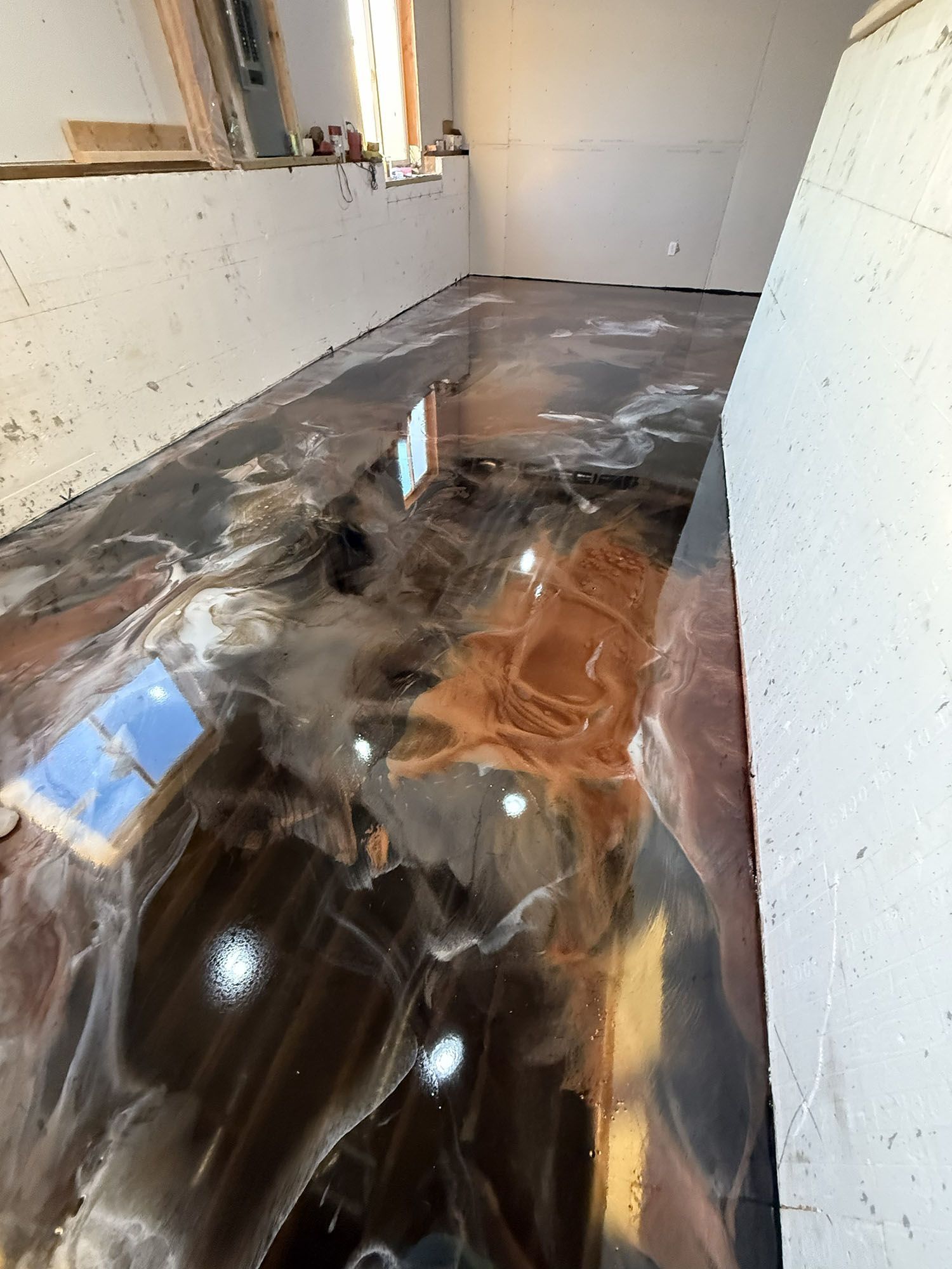 Glossy epoxy floor in a narrow hallway with reflective marbled brown, black, and white patterns.