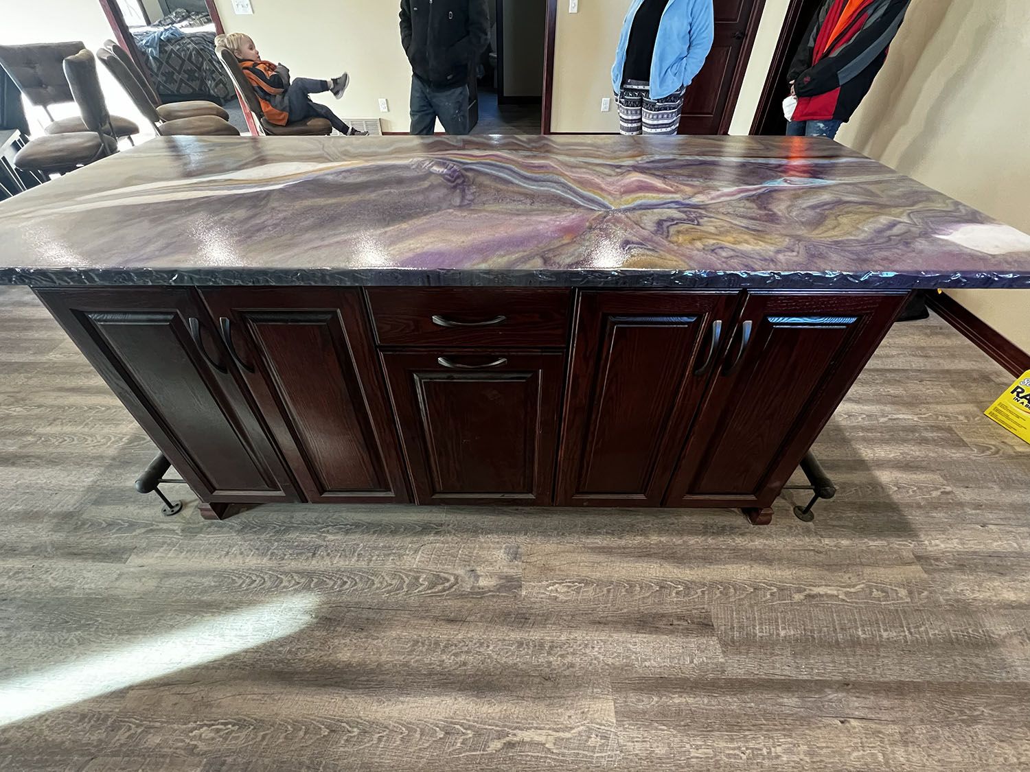 Dark wood buffet cabinet with marble top in a showroom.