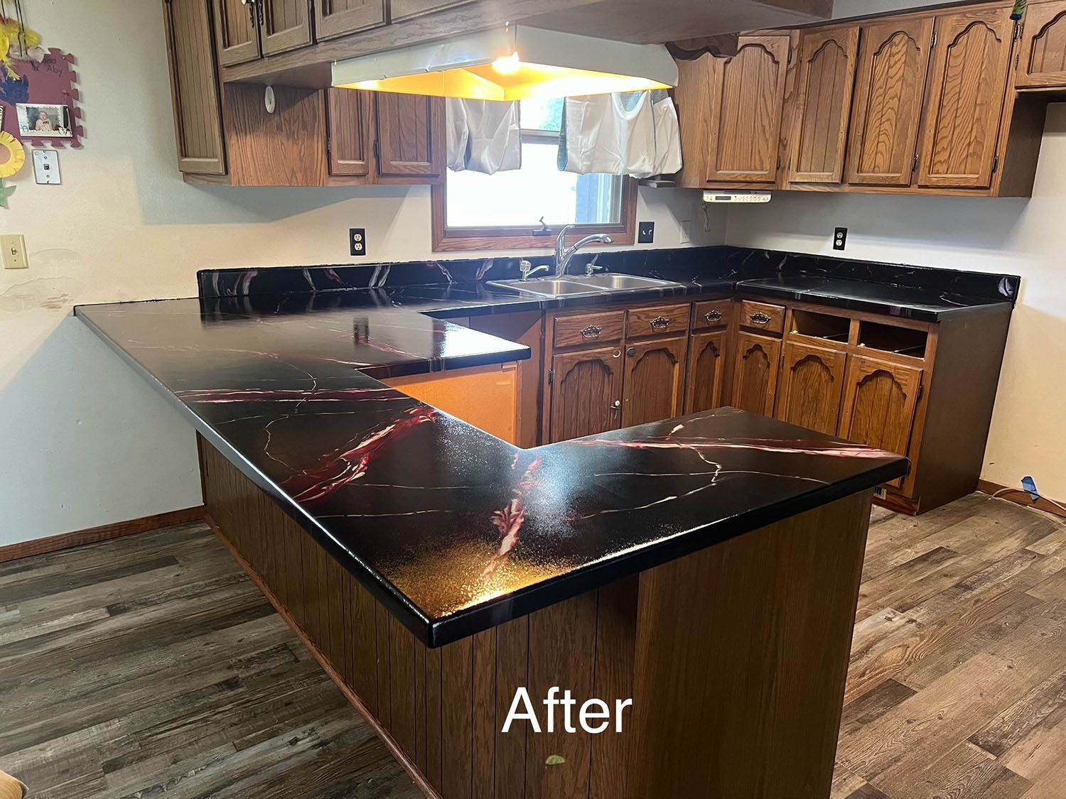 Kitchen with black granite countertops, wood cabinets, and a central island.