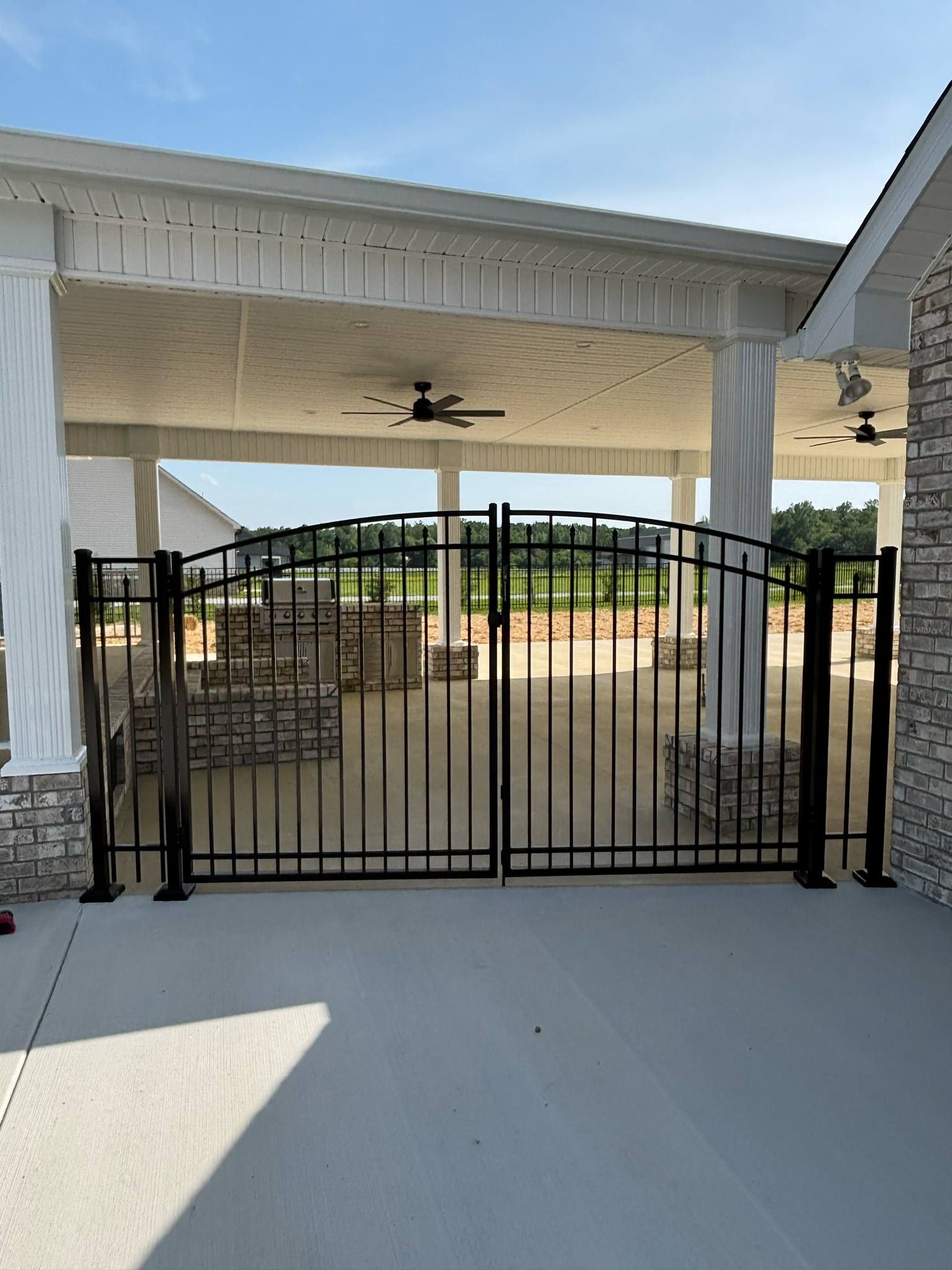 A black gate is sitting in front of a stone building.