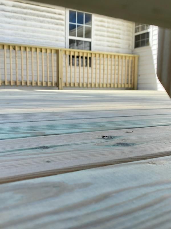 A white house with a wooden deck in front of it