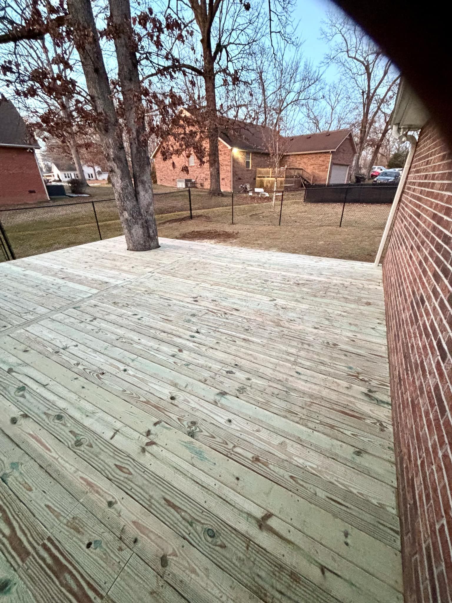A wooden deck with a brick building in the background.