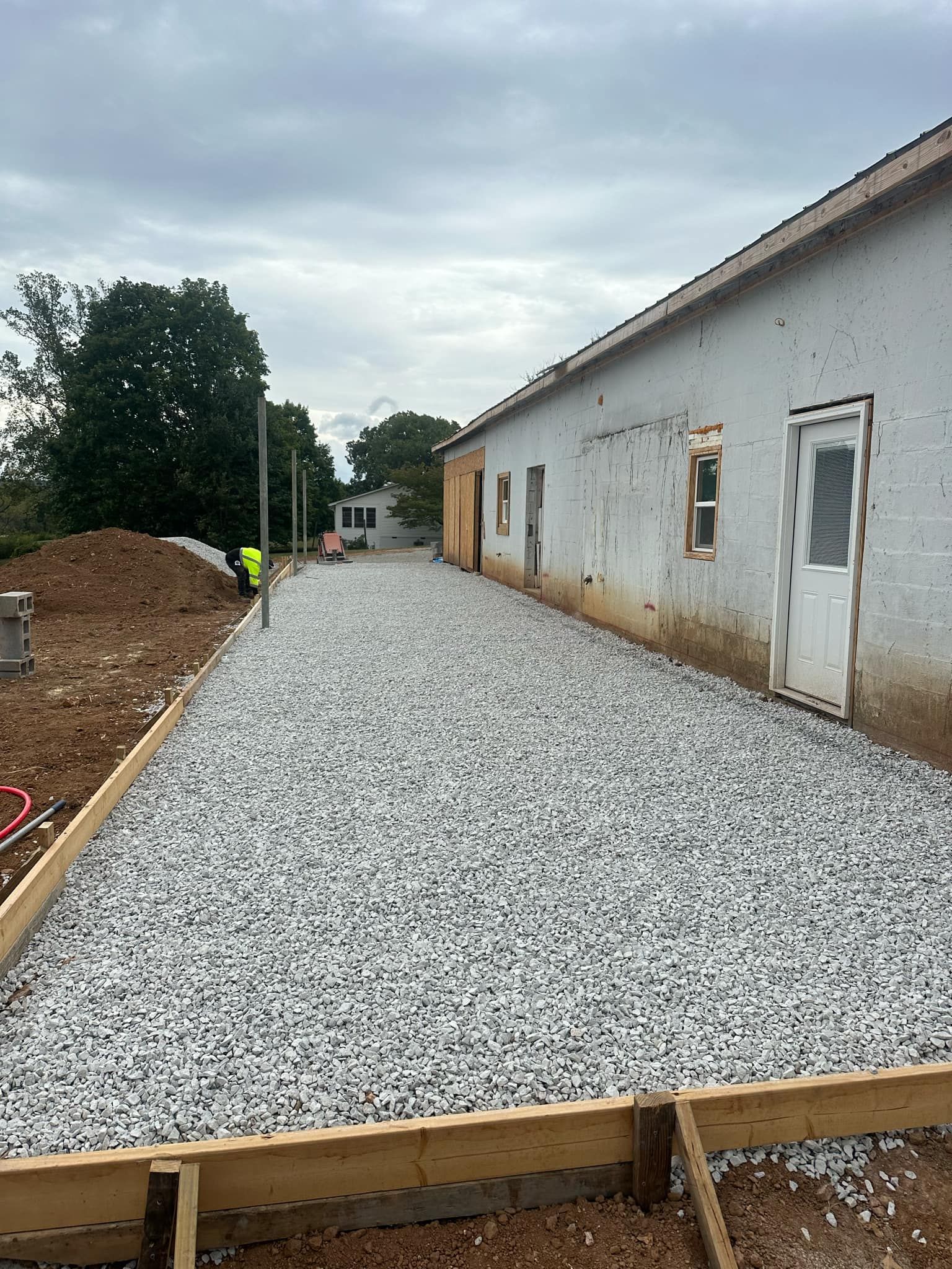 A gravel driveway is being built in front of a building.