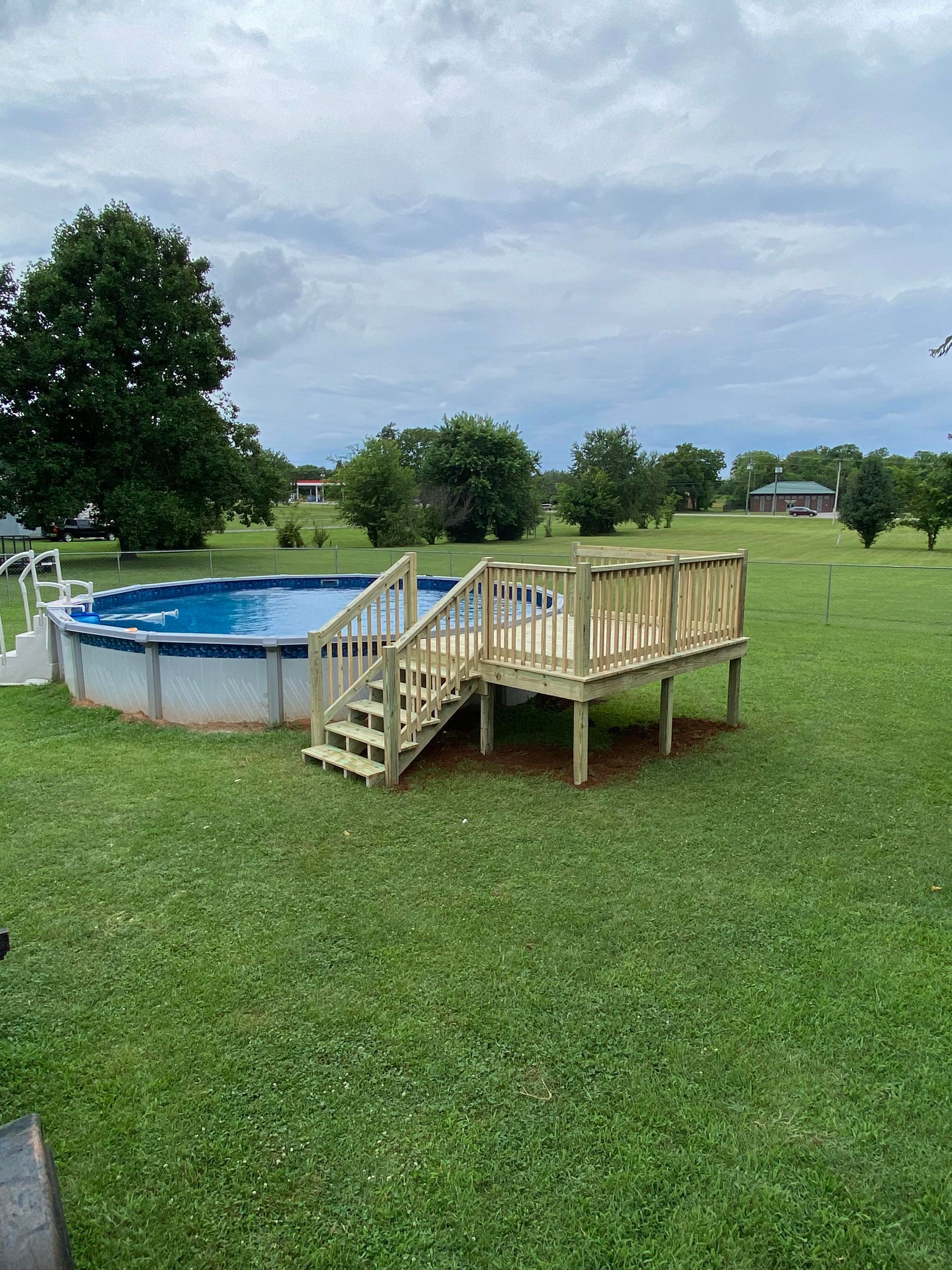 A swimming pool with a wooden deck attached to it.