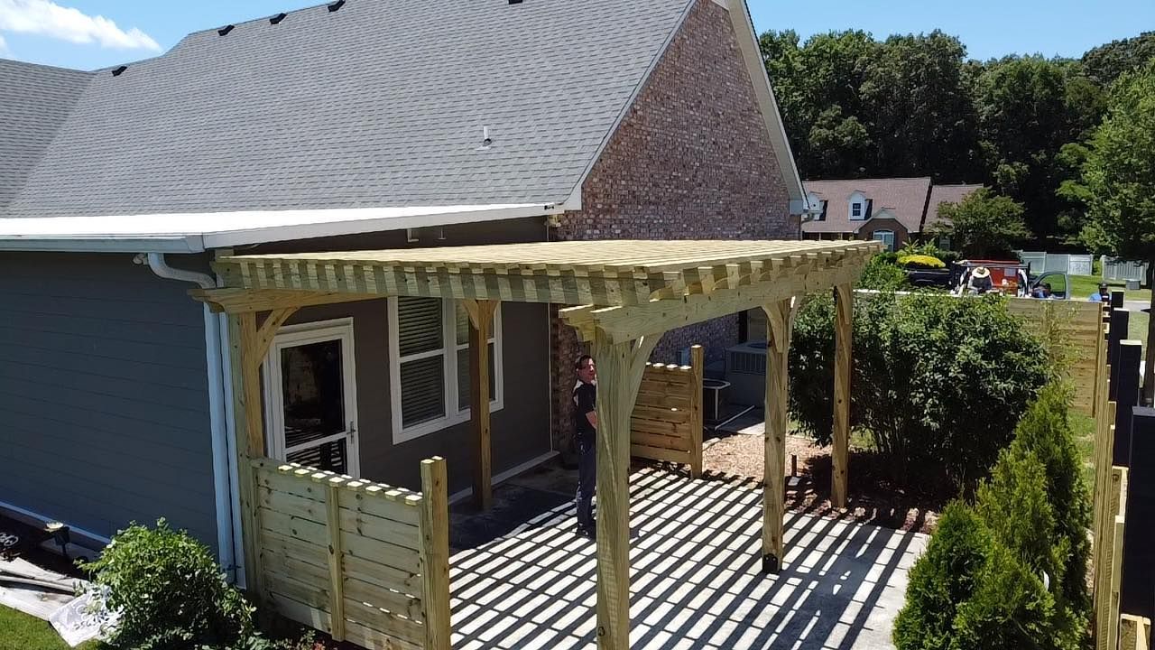 An aerial view of a house with a pergola in front of it.