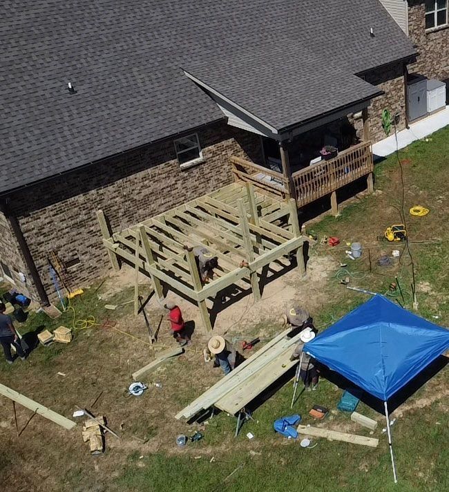 An aerial view of a deck being built in front of a house