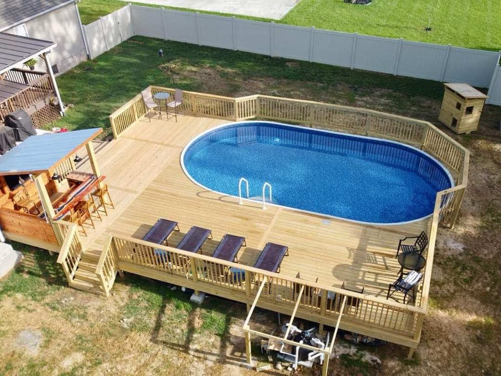 An aerial view of a swimming pool with a wooden deck surrounding it.