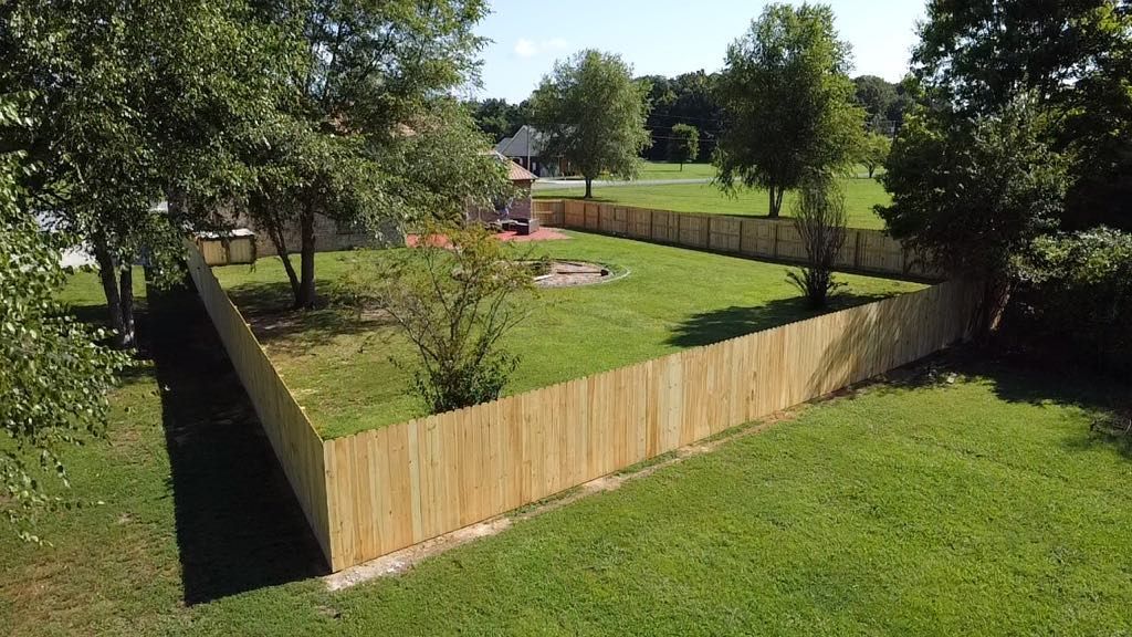 An aerial view of a backyard with a wooden fence and trees.