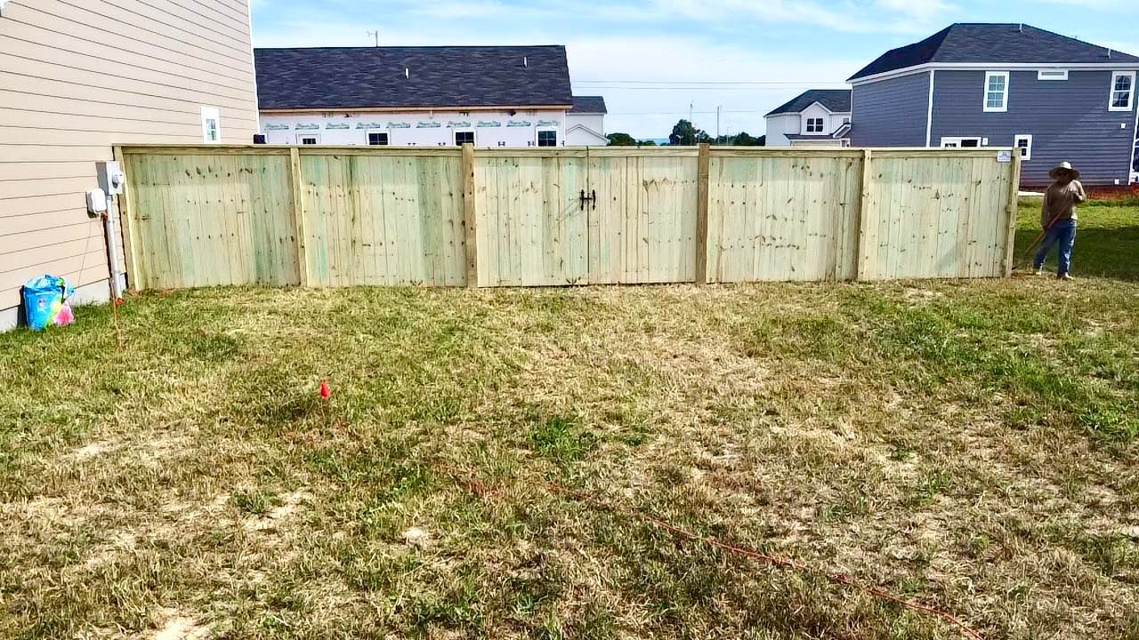 A wooden fence is sitting in the middle of a grassy field.