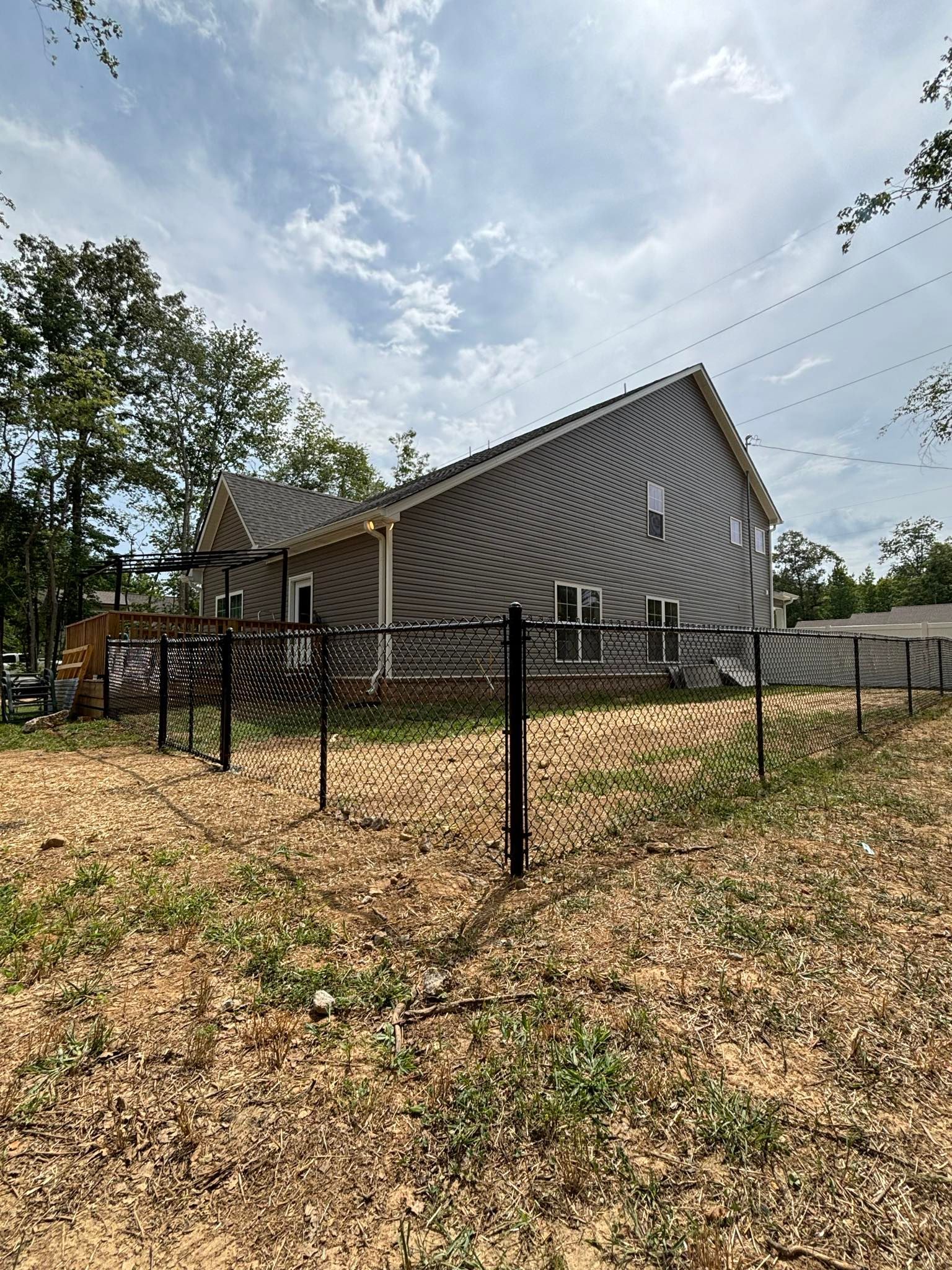 A house with a fence around it is sitting on top of a hill.