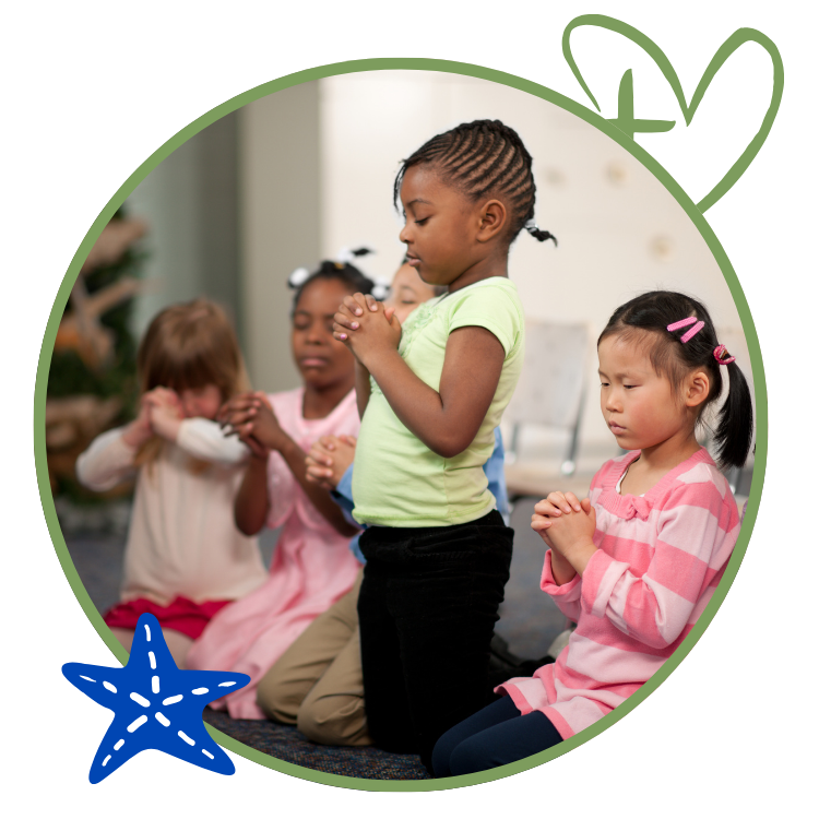 Children kneeling with hands clasped in prayer.