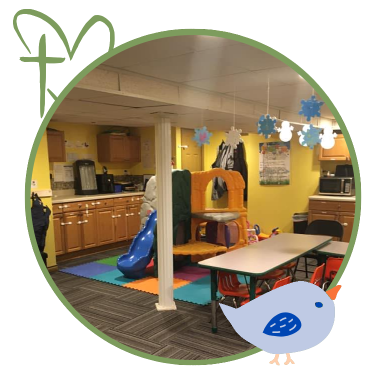 Playroom with slide, table, cabinets, and colorful floor mats.
