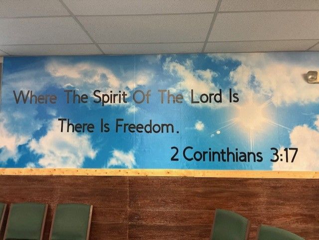 Mural with blue sky and clouds, text Where The Spirit Of The Lord Is There Is Freedom. 2 Corinthians 3:17.