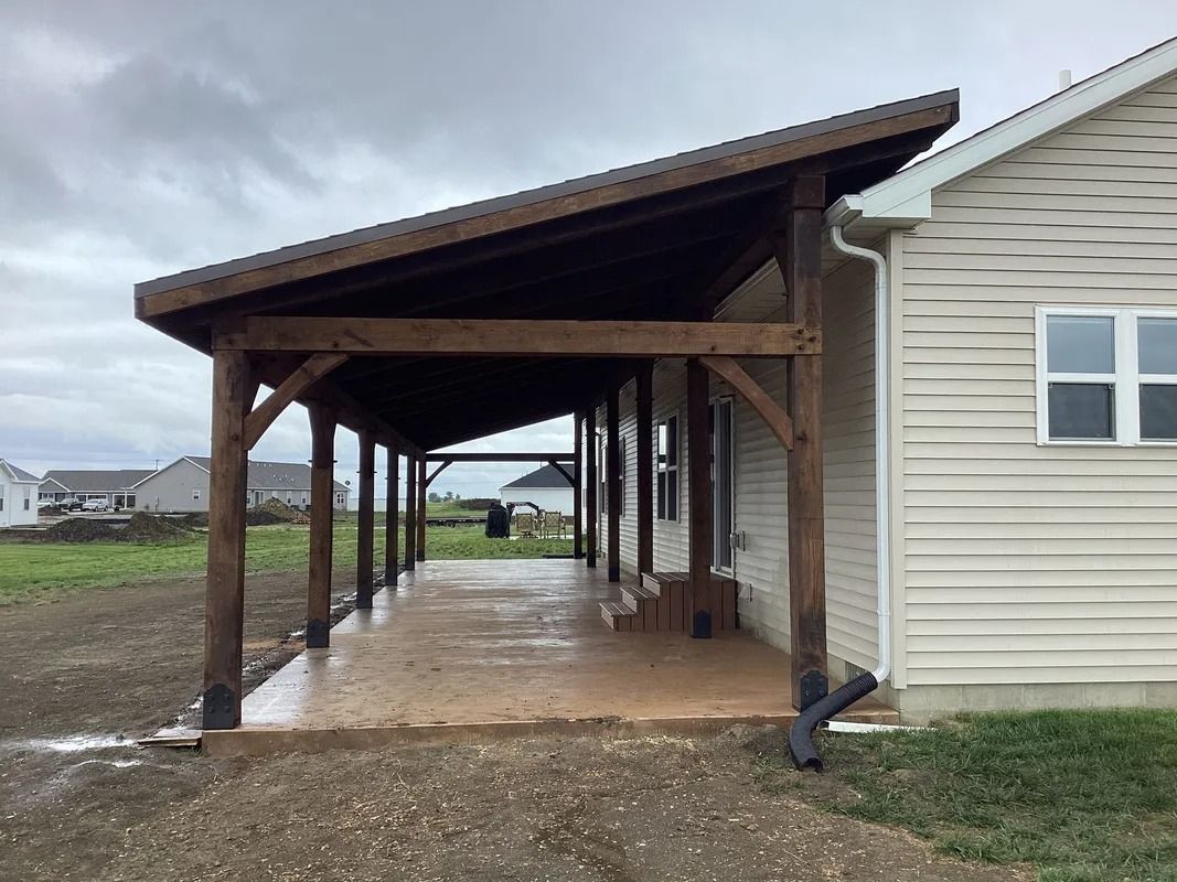 Covered wooden walkway beside a house on a muddy rural property