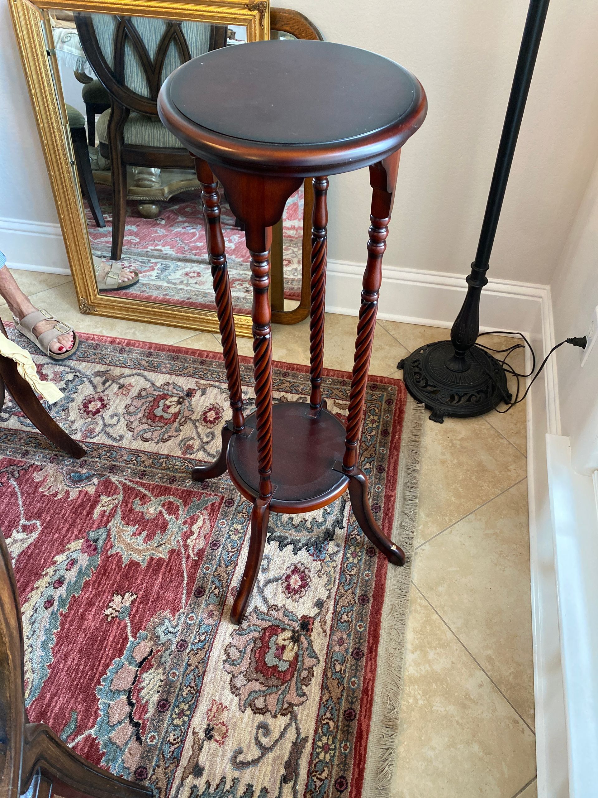 A wooden table with a black top is sitting on a rug in a living room.