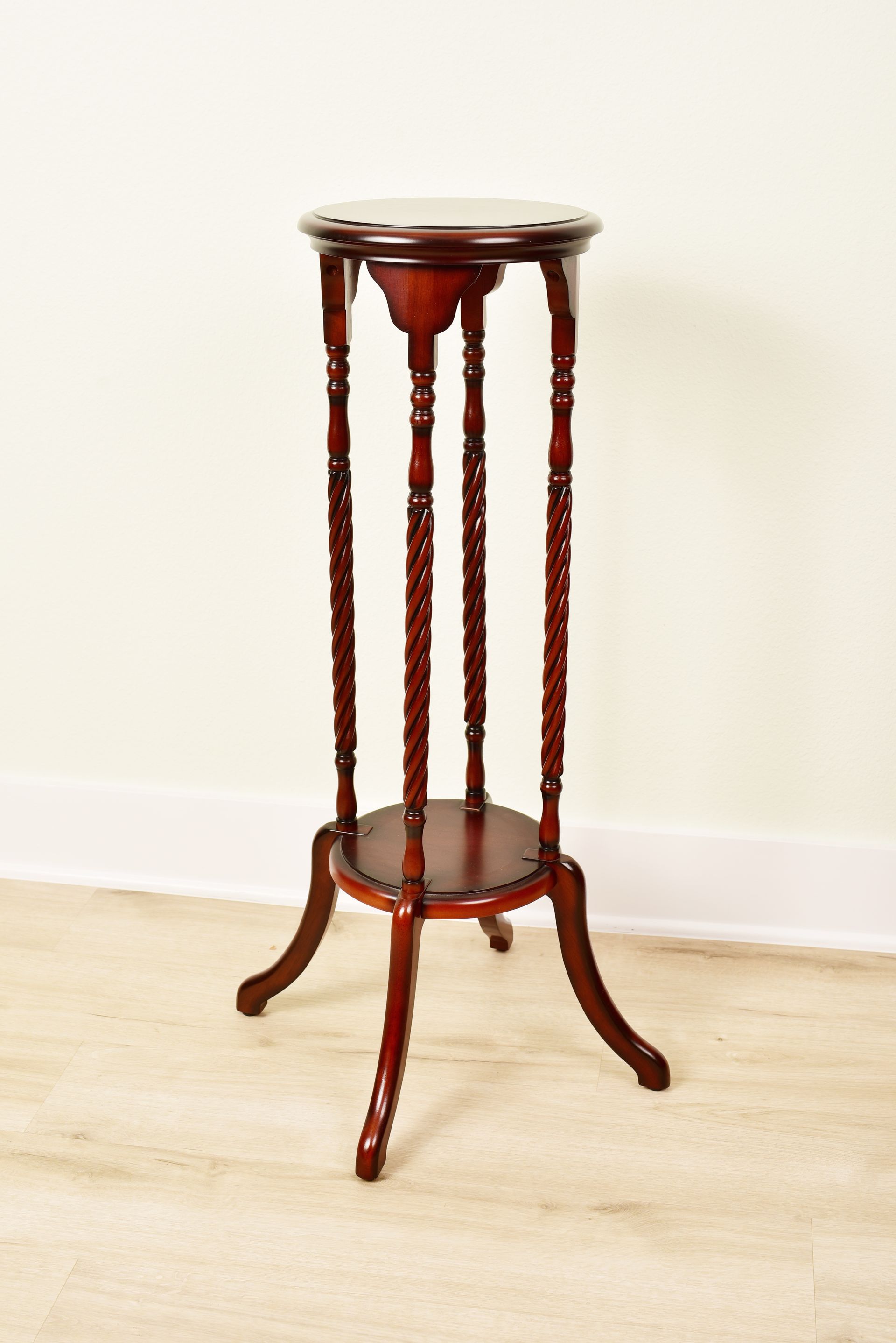 A wooden plant stand is sitting on a wooden floor.