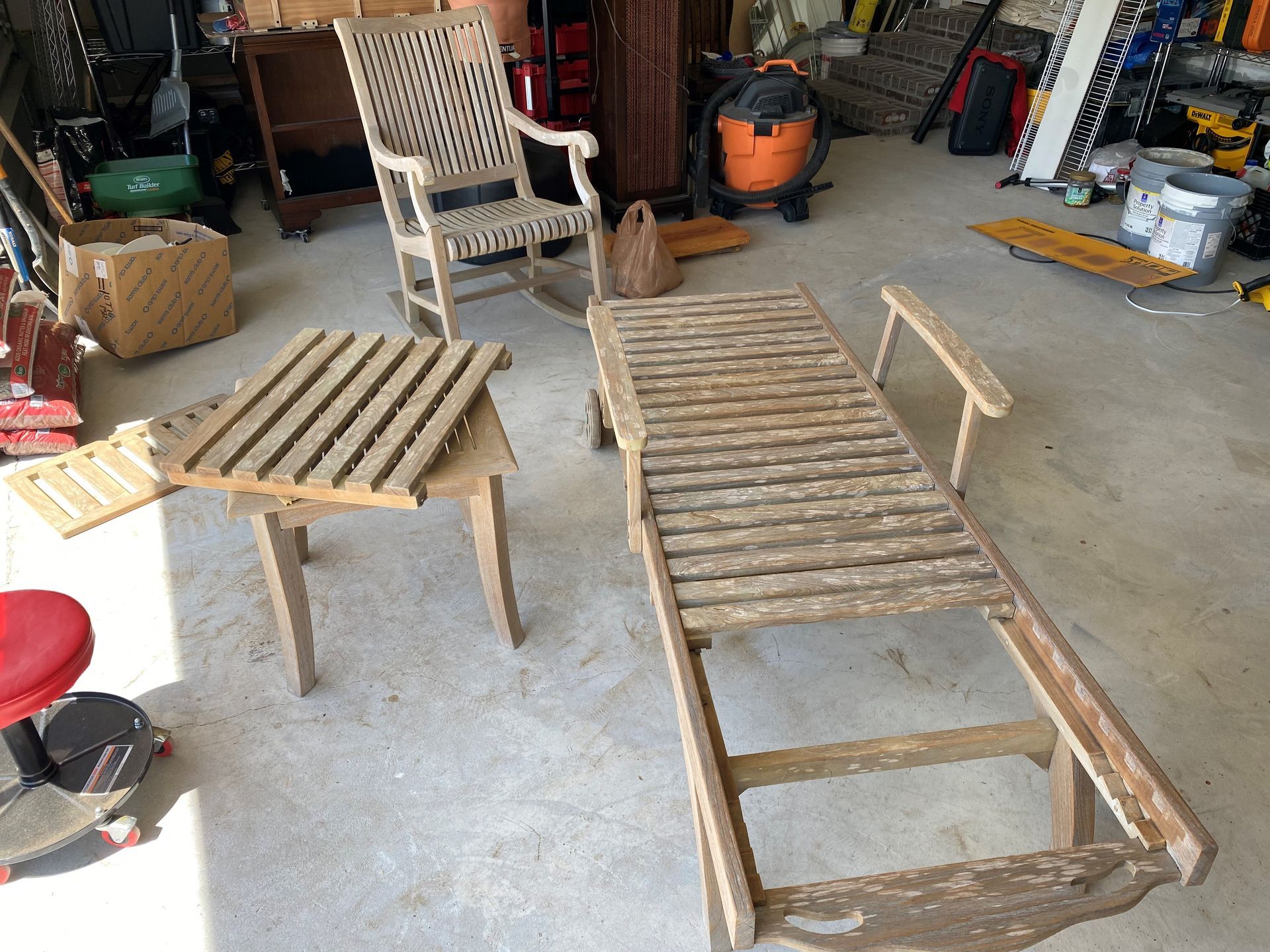 A wooden rocking chair and a wooden table are in a garage.