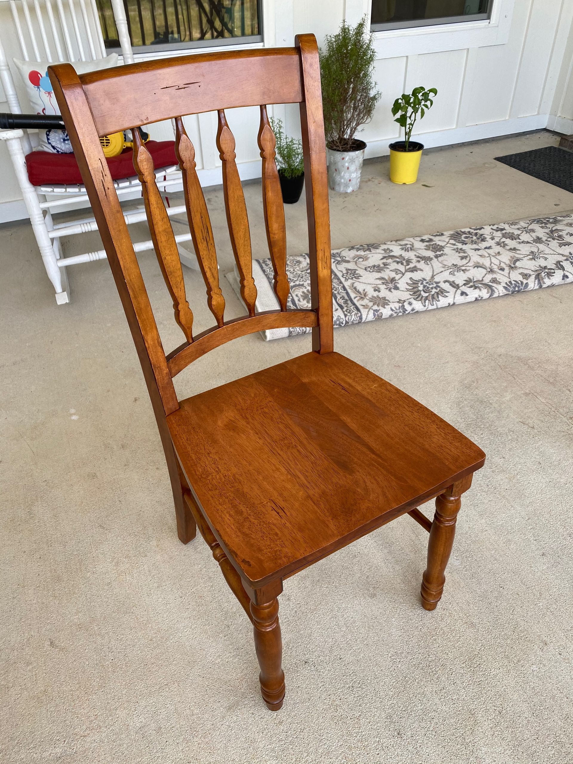 A wooden chair is sitting on a carpet in a living room.