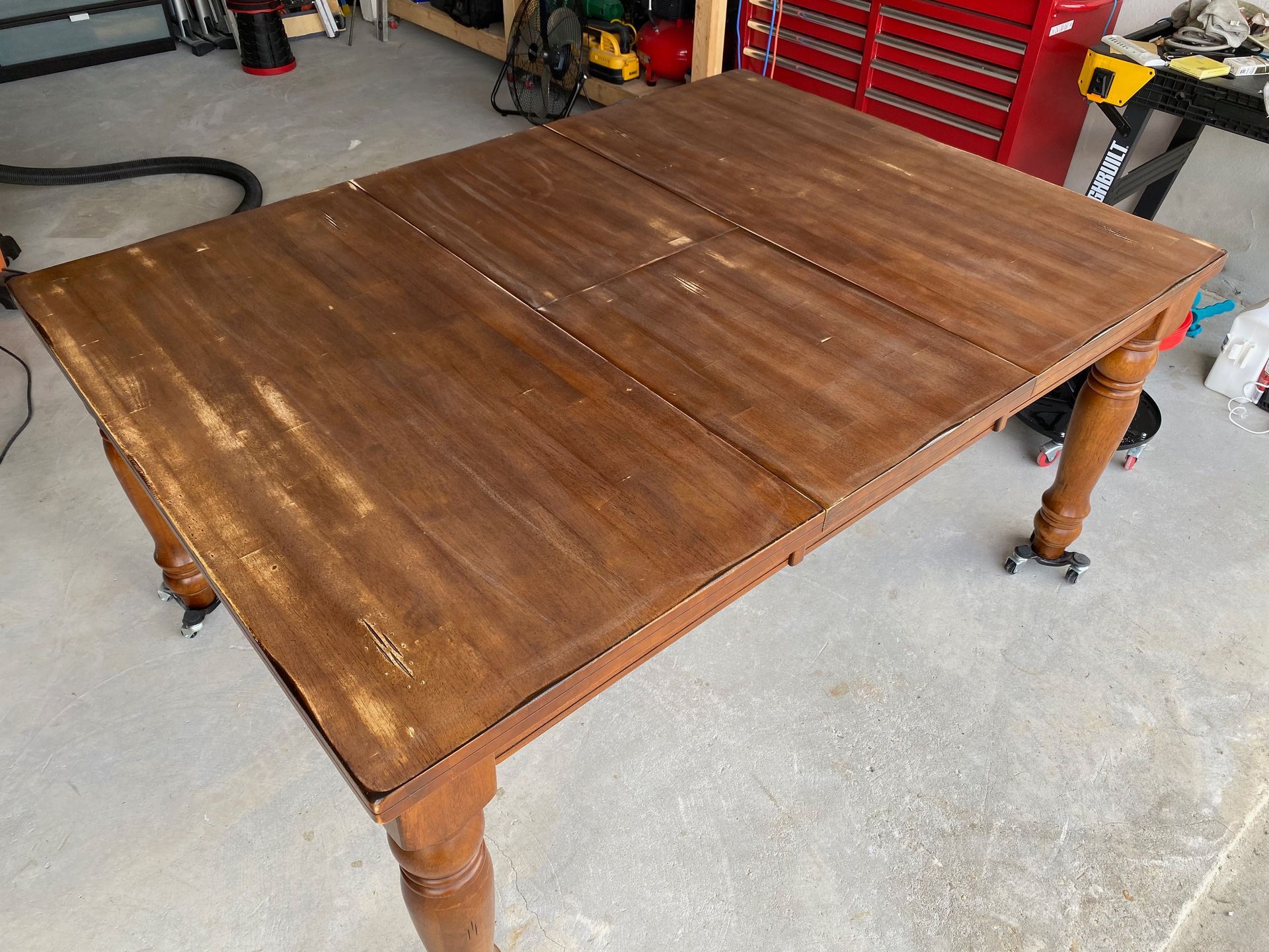 A wooden table is sitting on a concrete floor in a garage.
