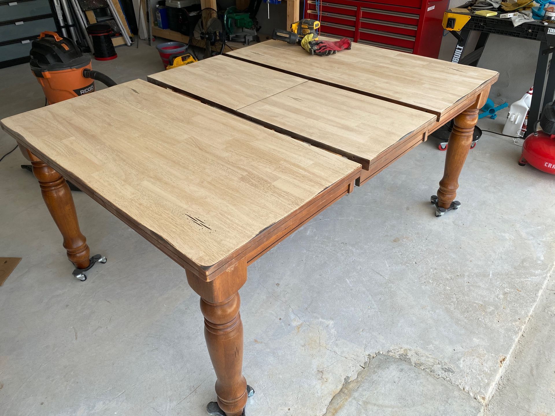 A wooden table is sitting on a concrete floor in a garage.
