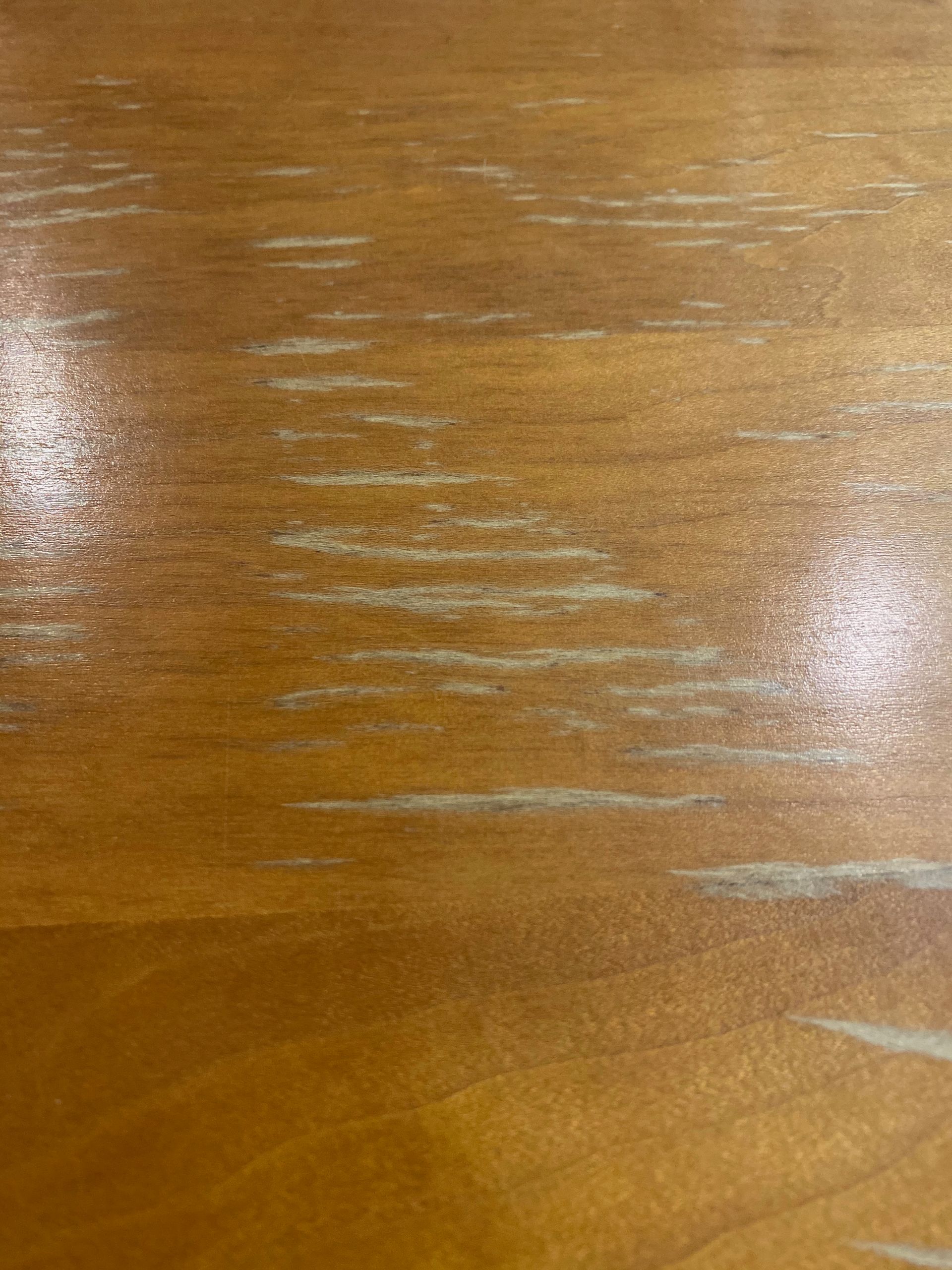 A close up of a wooden table with a lot of scratches on it.